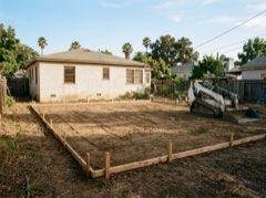 Compacted dirt ADU pad in a Los Angeles backyard with forms staked out