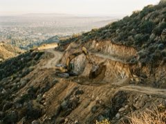 Excavator benching a steep Los Angeles hillside lot